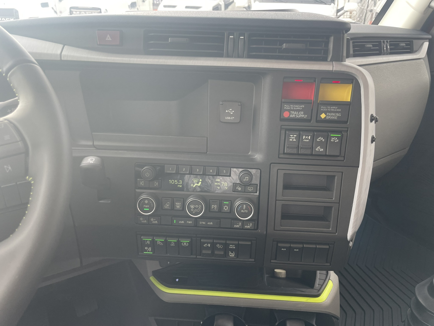 Volvo VNL64T860 cab interior dashboard and center console with climate controls, switchgear, and storage compartments visible.