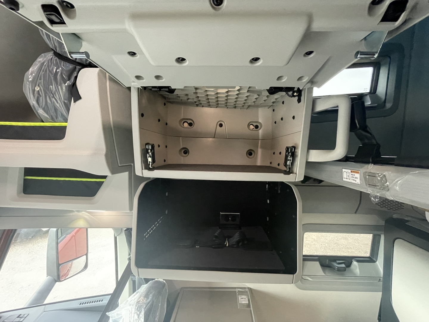 Volvo VNL interior view showing undercab area and storage compartments from cabin floor; visible panels and mounting points.