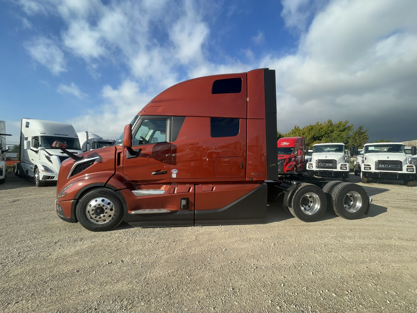 Volvo VNL64T860 sleeper tractor in side view showing cab and rear axle with orange paint and black accents.