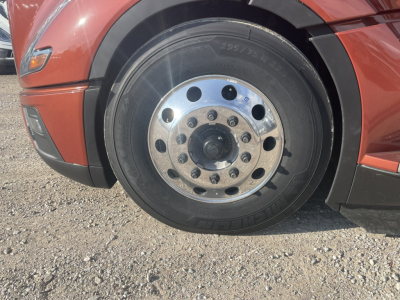 Volvo truck front wheel showing steel wheel with multiple lug nuts and tire sidewall markings.