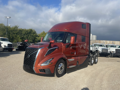 Volvo VNL64T860 truck front-left view in red, with sleeper cab and three axles visible.