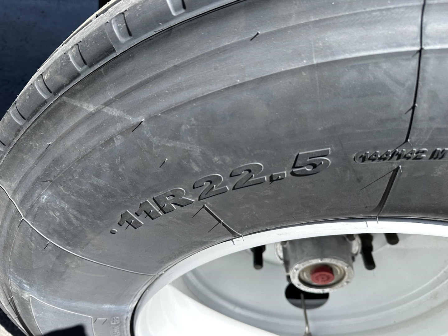 Tire close-up showing sidewall marking ./HR 22.5 on a trailer wheel.