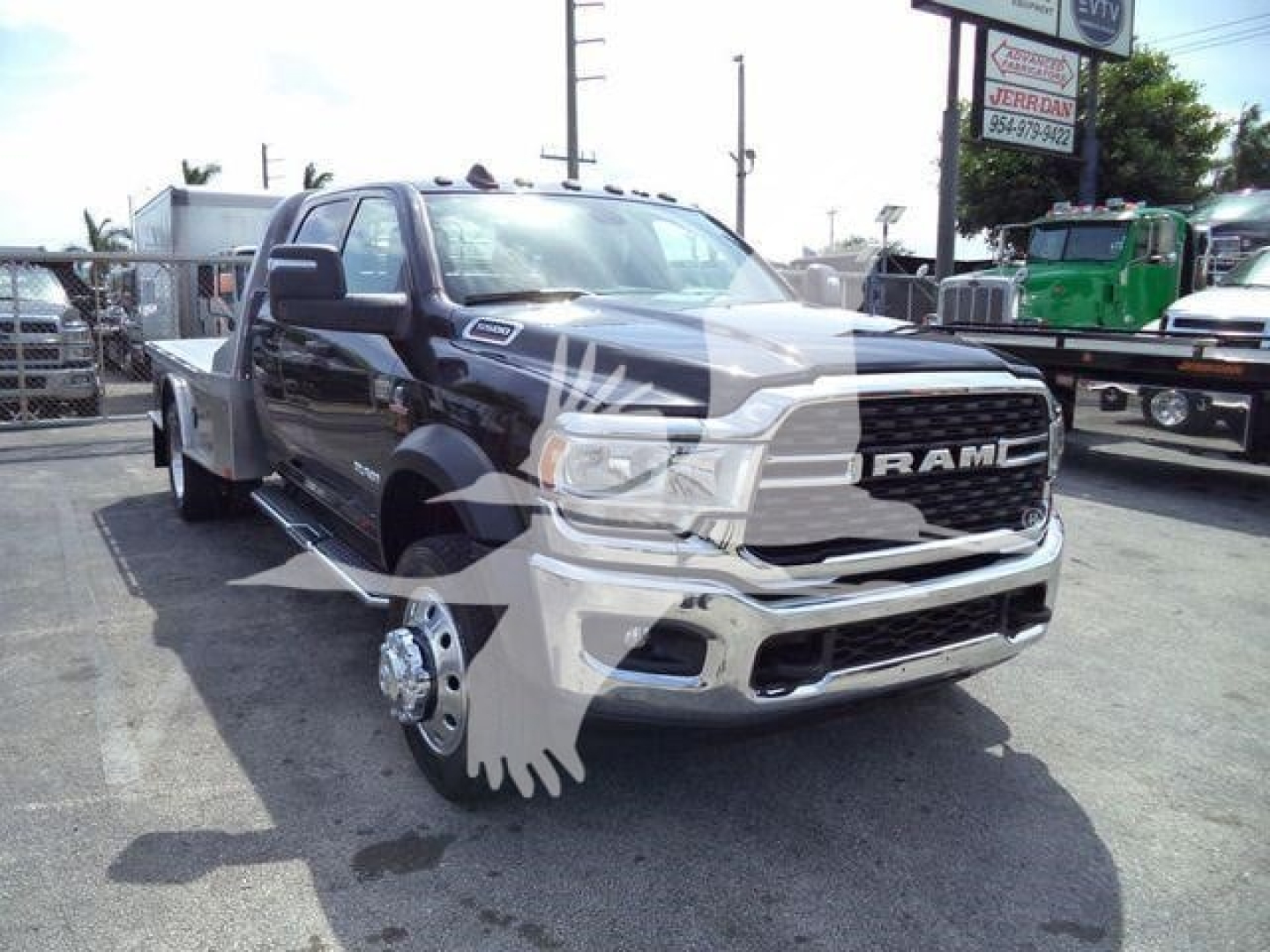 Ram 5500 SLT dump truck front view showing chrome grille and RAM badge, front wheel removed revealing brake components.