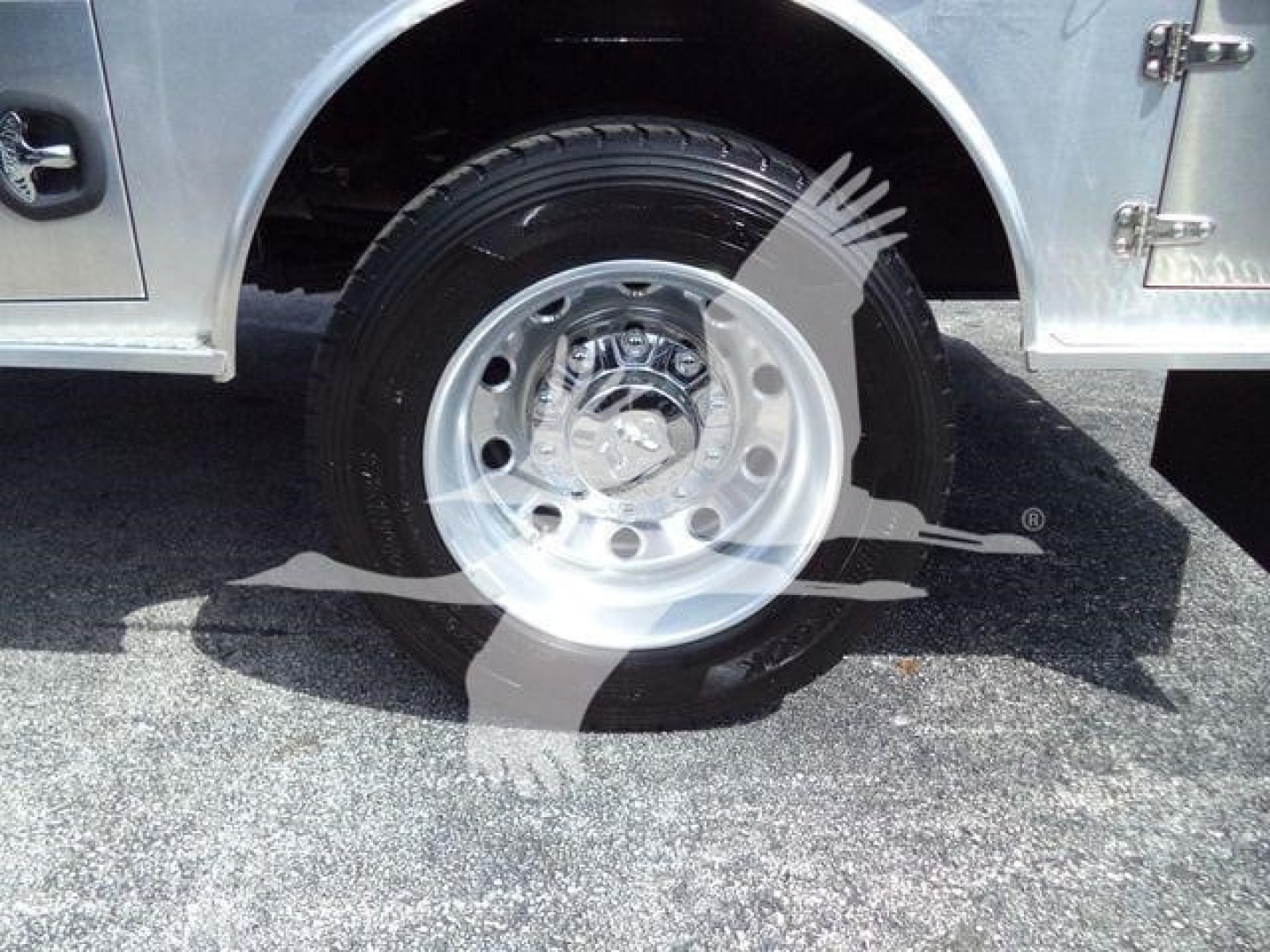 Ram 5500 wheel and tire close-up in truck bed area showing silver hub, black tire, and chrome wheel center cap.