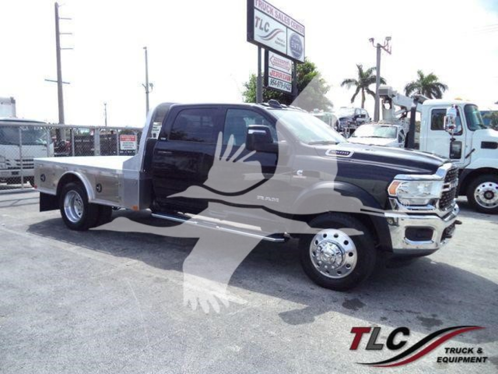 Ram 5500 truck in service bay showing front cab and long flatbed with dual rear wheels and large side mirror panels.