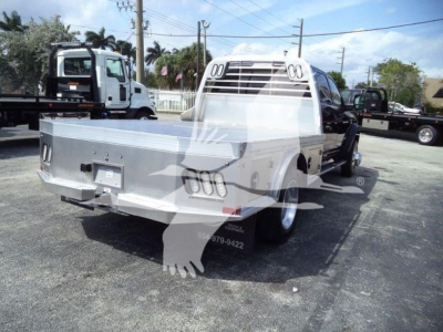 Ram 5500 SLT flatbed truck rear view showing aluminum bed and cab with chrome grille and dual rear wheels.