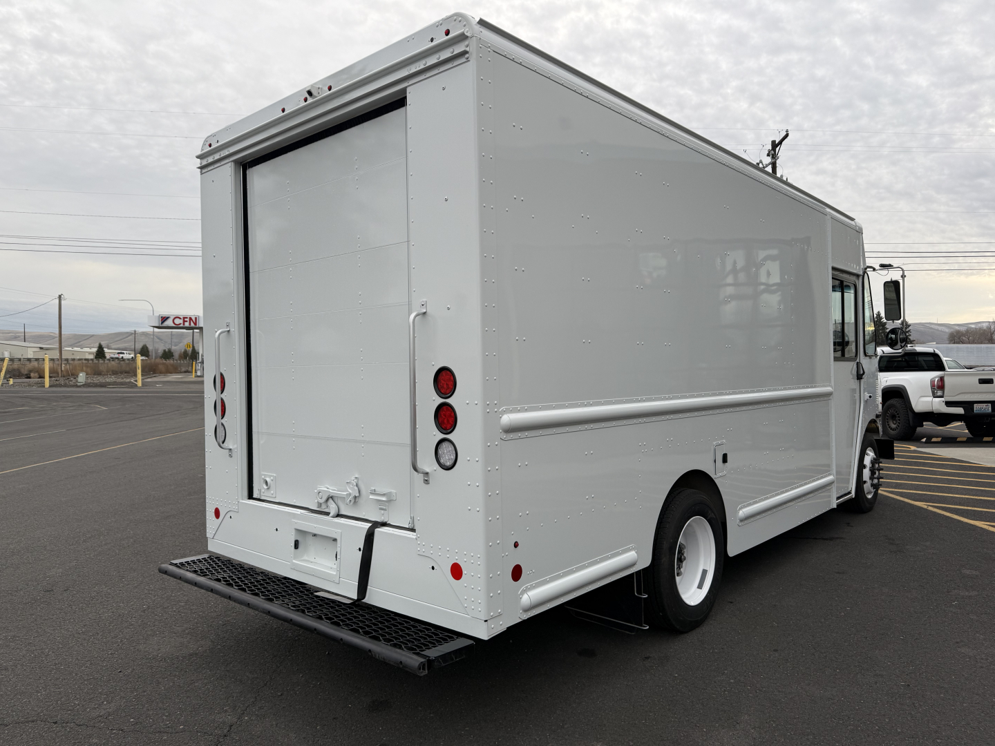 Harbinger S525 step van rear view showing roll-up rear doors, cargo body, white paint, tail lights, and bumper.