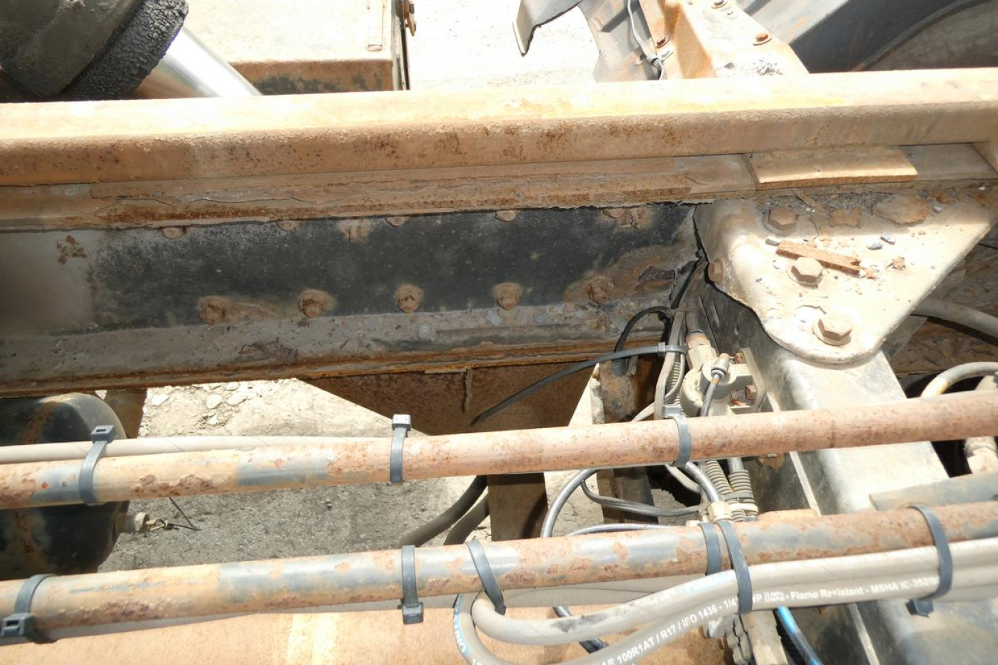 Kenworth T800 chassis frame with hydraulic lines and rust-free tubing, view of underside and hitch area.