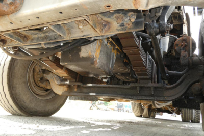 Underbody view of a 2003 Kenworth T800 showing drivetrain, suspension, and steel components.