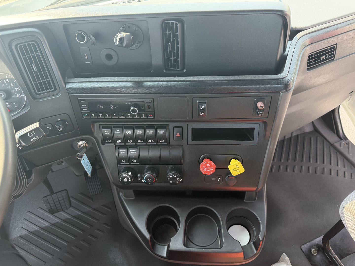 Dashboard interior of a 2022 International LT625 truck showing control panel, gauges, and cup holders.