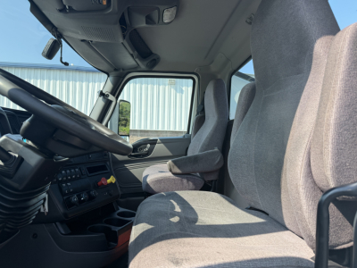 Cab interior of a 2022 International LT625 truck showing steering wheel, driver's seat, and dashboard with control panel.