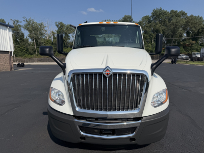 Truck front view showing International LT625 grille and bumper with large black mirrors.