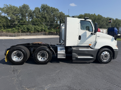 Truck chassis side view showing International LT625 conventional daycab with white cab and dual rear axles, fuel tanks, and steps.