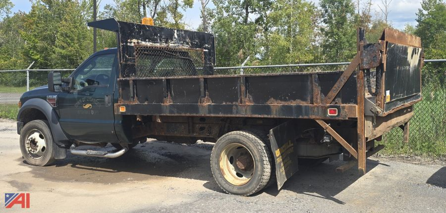Ford F-450 XL Super Duty dump truck in-service showing metal dump bed with rust and a rear tailgate, VIN plate on side; side panels and wheel wells visible.