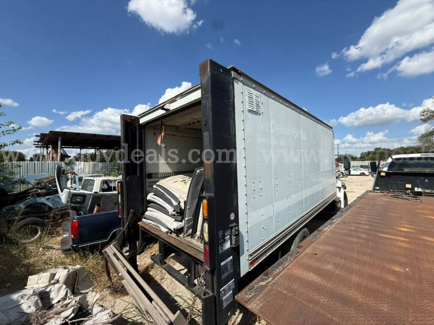 Box truck showing cargo area with open rear doors and ramp, International 4400 style body