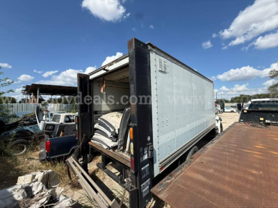Box truck showing cargo area with open rear doors and ramp, International 4400 style body
