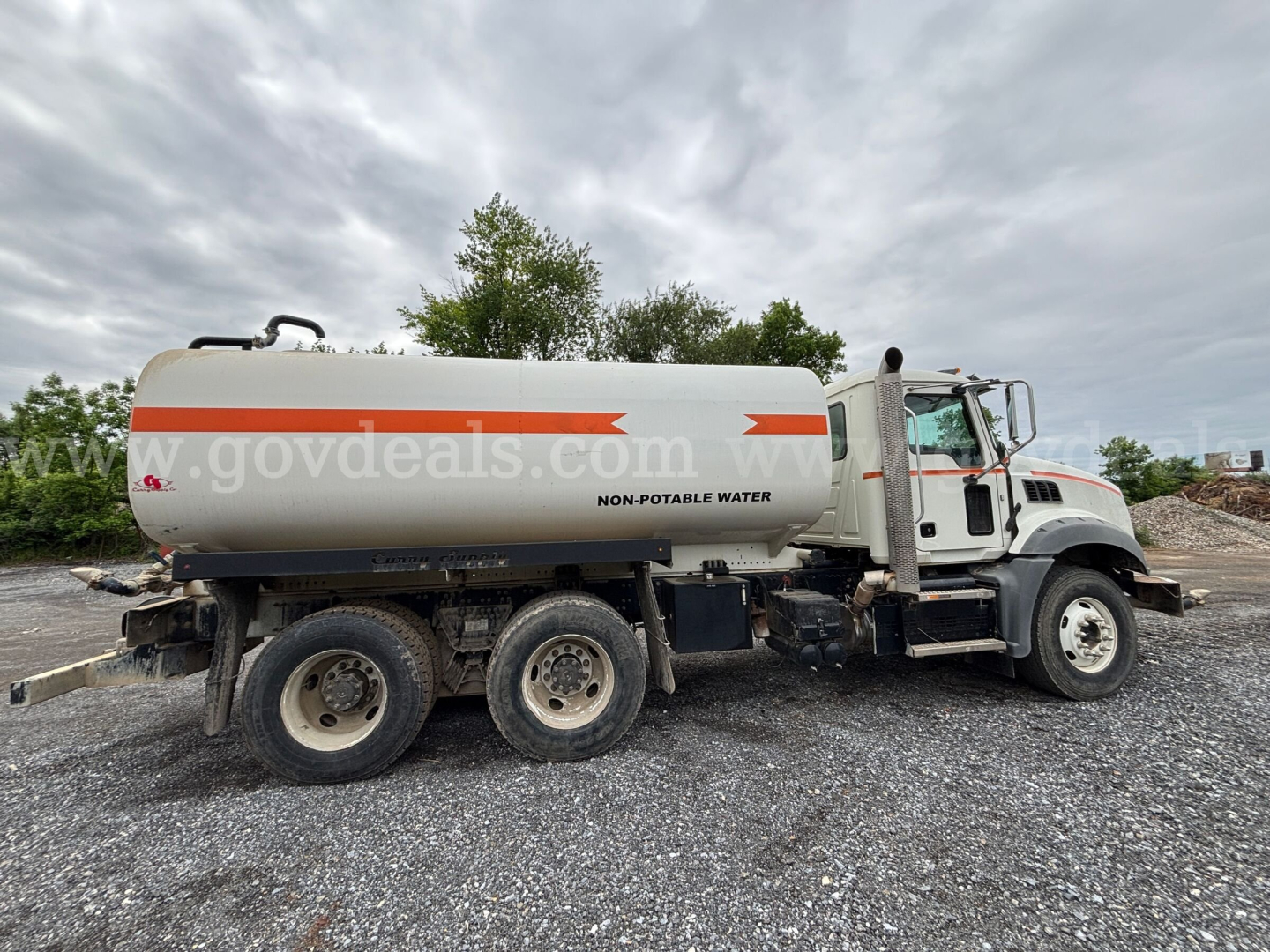 Tank truck with 4-axle configuration showing NON-POTABLE WATER on white tank and Mack Granite cab, side view.