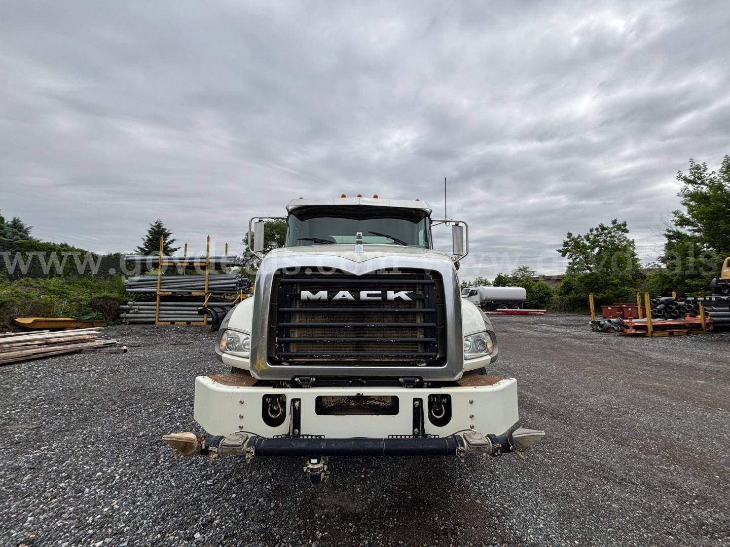 Front view of a 2020 Mack Granite 64BR MHD dump truck showing large black grille with 'MACK' emblem, white bumper, and headlights.
