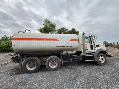 Tank truck with 4-axle configuration showing NON-POTABLE WATER on white tank and Mack Granite cab, side view.