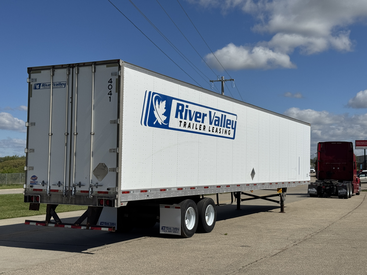 Trailer shown in a parking lot with River Valley Trailer Leasing logo on the side and rear doors open. 2014 Utility 4000D-X trailer.