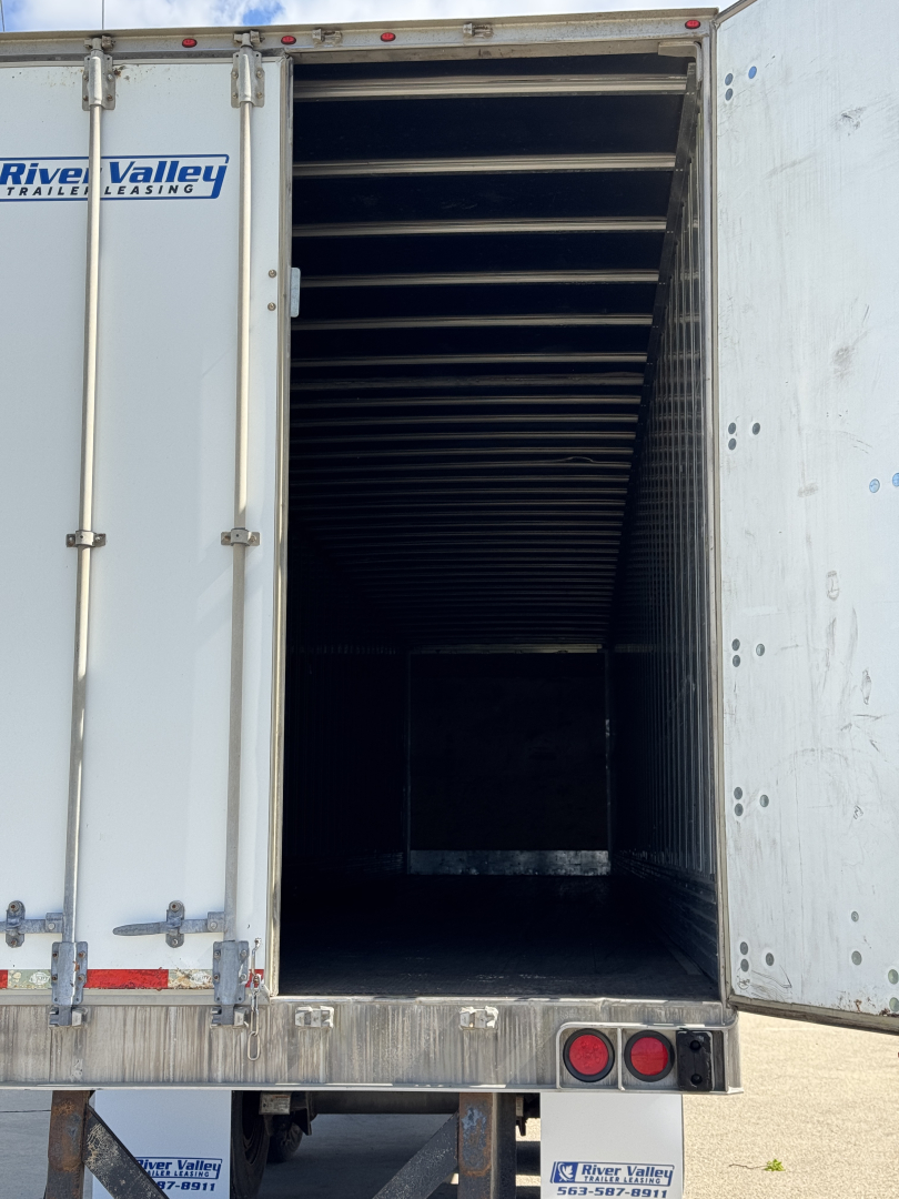 Trailer rear opening showing empty interior with ribbed walls, River Valley logo on left door, and taillights at bottom right.
