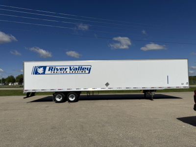 Trailer side showing River Valley Trailer Leasing logo, long white utility trailer with dual rear axles, blue sky.