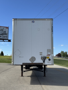 Rear view of a 2014 Utility 4000D-X trailer showing utility vehicle rear with reflectors, taillights, and support legs.