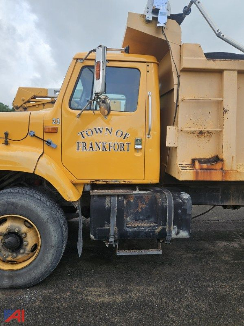 Truck cab close-up showing yellow 2000 International 2674 dump truck with Town of Frankfort lettering on door and dump bed in view.