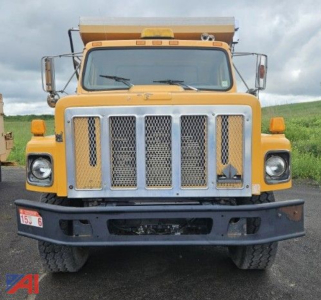 Front view of a yellow 2000 International 2674 Dump Truck showing large chrome grille, bumper, and dual side mirrors.