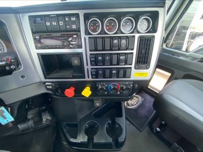 Dashboard of a 2021 Mack PI64T truck showing instrument cluster, controls, radio, climate dials, and cup holders.