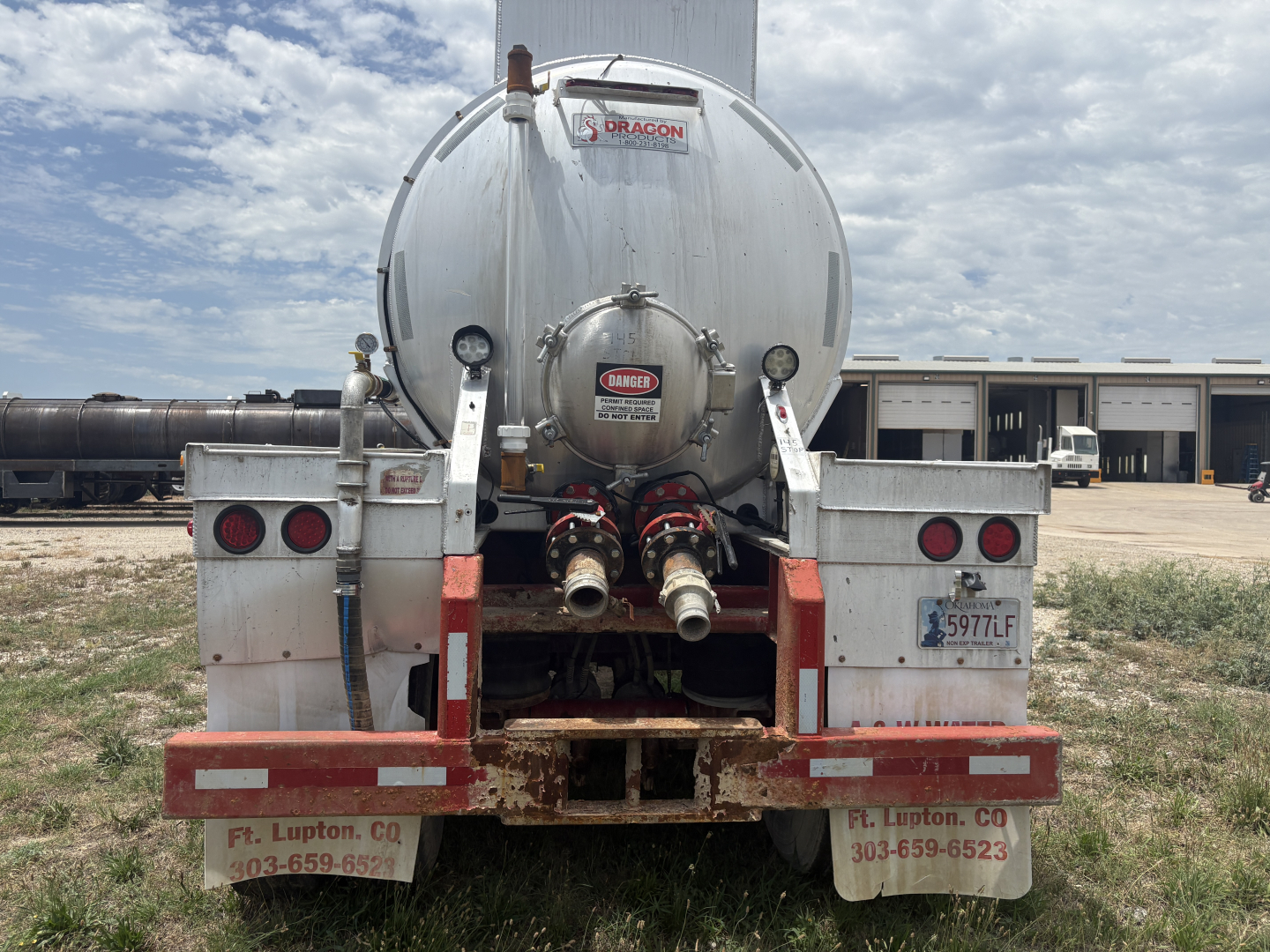 Back view of 2012 Dragon 150BBL vacuum trailer showing rear hoses and dual taillights with Diamond Dragon label on tank.