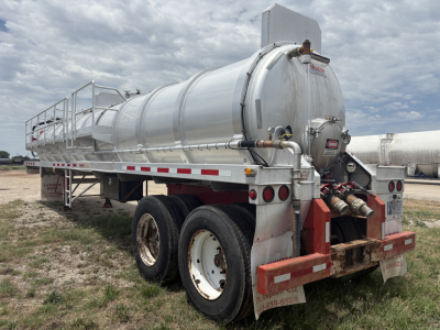 Semi-trailer vacuum tanker in side and rear view showing cylindrical stainless steel tank with rear coupler and dual axle wheels.