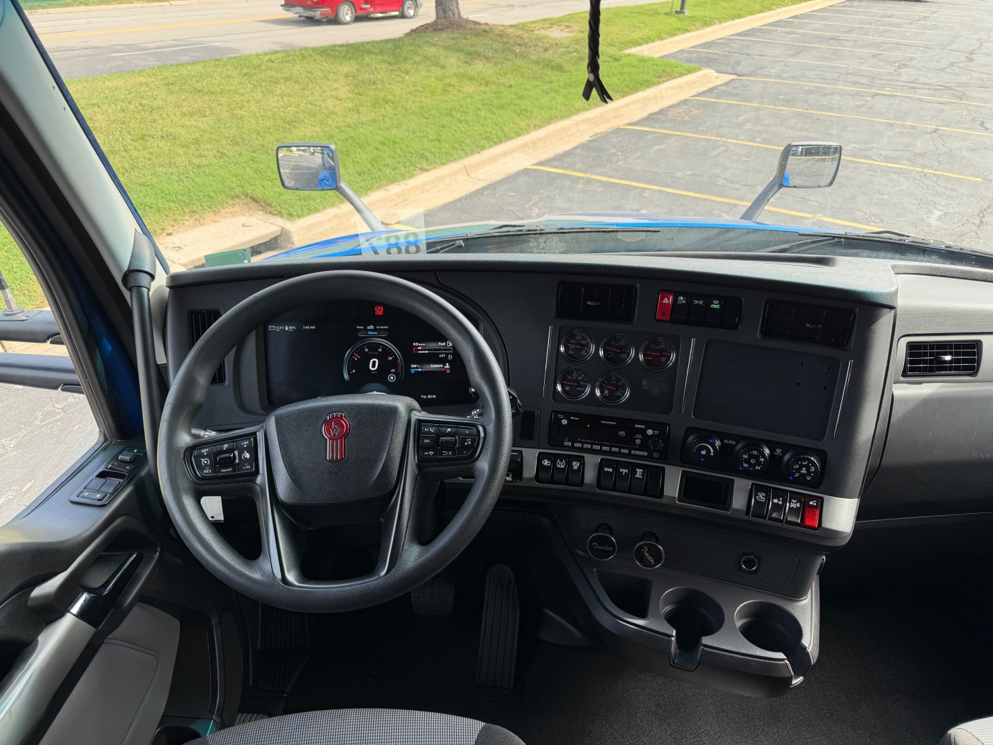 Kenworth T680 truck cockpit interior with steering wheel, dashboard gauges, and central console.