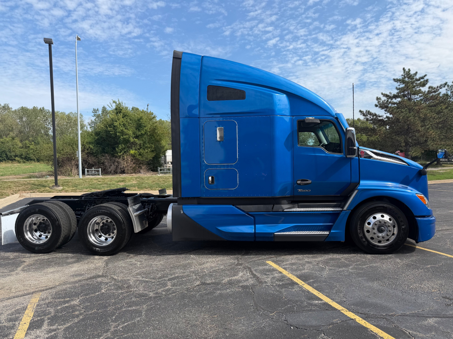 Kenworth T680 6x4 sleeper cab blue semi with chrome wheels side view showing cab and chassis