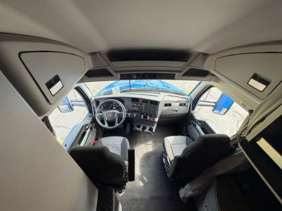Kenworth T680 truck interior view from cab showing steering wheel, dashboard, and front seats.