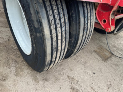 Quad trailer wheel assembly with multiple tires and red frame, visible tread details.