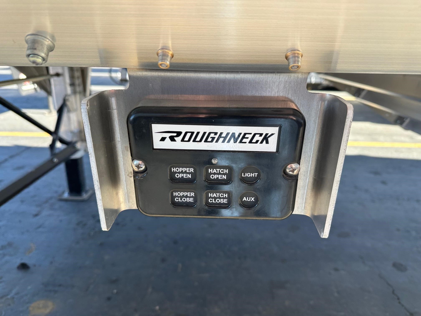 Roughneck hopper trailer control panel with 'ROUGHNECK' logo and buttons labeled HOPPER OPEN, HATCH OPEN, HOPPER CLOSE, HATCH CLOSE, LIGHT, AUX.