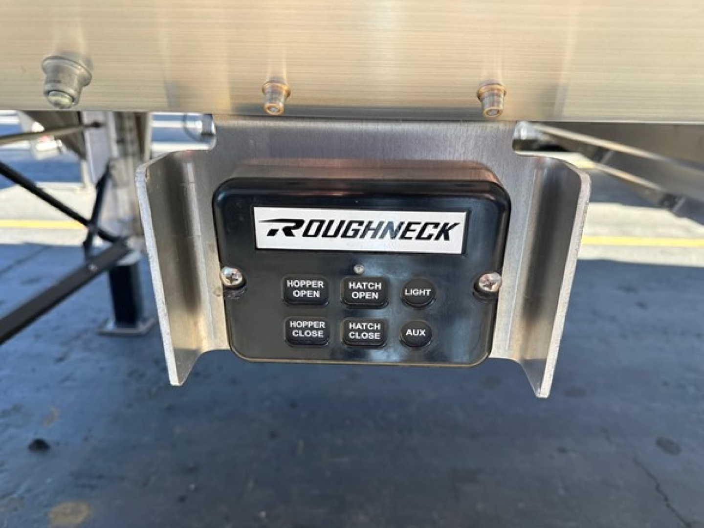 Roughneck hopper bottom trailer control panel with brand 'ROUGHNECK' and buttons labeled HOPPER OPEN, HATCH OPEN, HATCH CLOSE, AUX, HOPPER CLOSE.