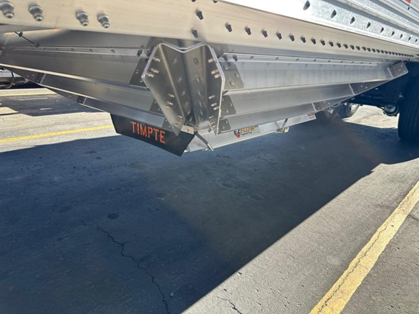 Trailer underside showing Timpte Roughneck hopper bottom with tailer and orange TIMPTE branding on the chute area.
