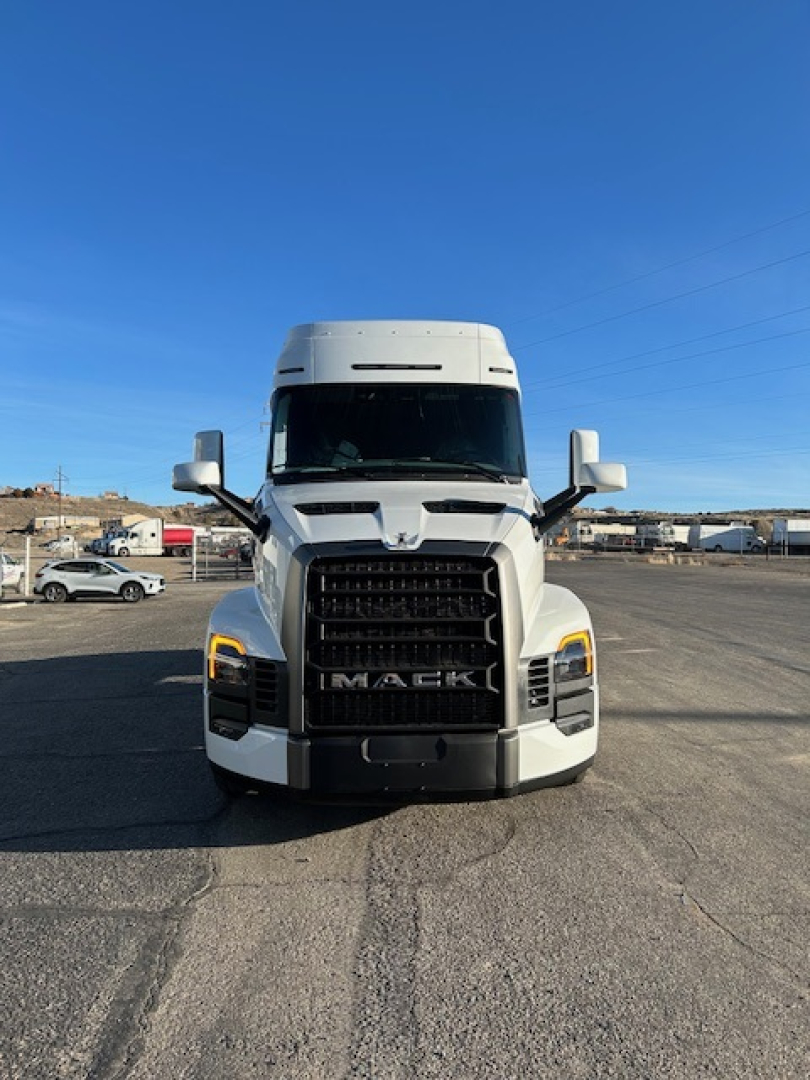 Front view of a white Mack PR64T64 truck tractor showing prominent grille with 'MACk' logo and headlight details.