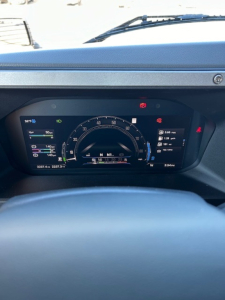 Dashboard of a Mack PR64T64 truck showing digital gauge cluster and warning indicators.
