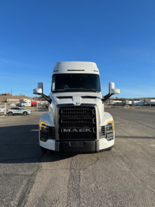 Front view of a white Mack PR64T64 truck tractor showing prominent grille with 'MACk' logo and headlight details.