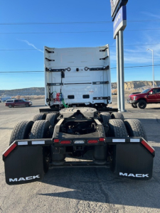 Rear view of a 2026 Mack PR64T64 tractor chassis showing fifth wheel area and dual rear axles with mud flaps labeled MACK.
