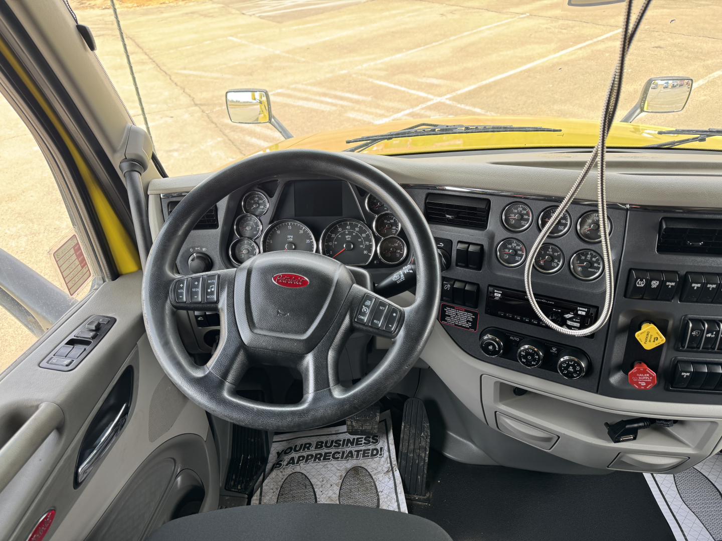 Peterbilt 579 cab interior showing steering wheel, instrument cluster, and dashboard controls.