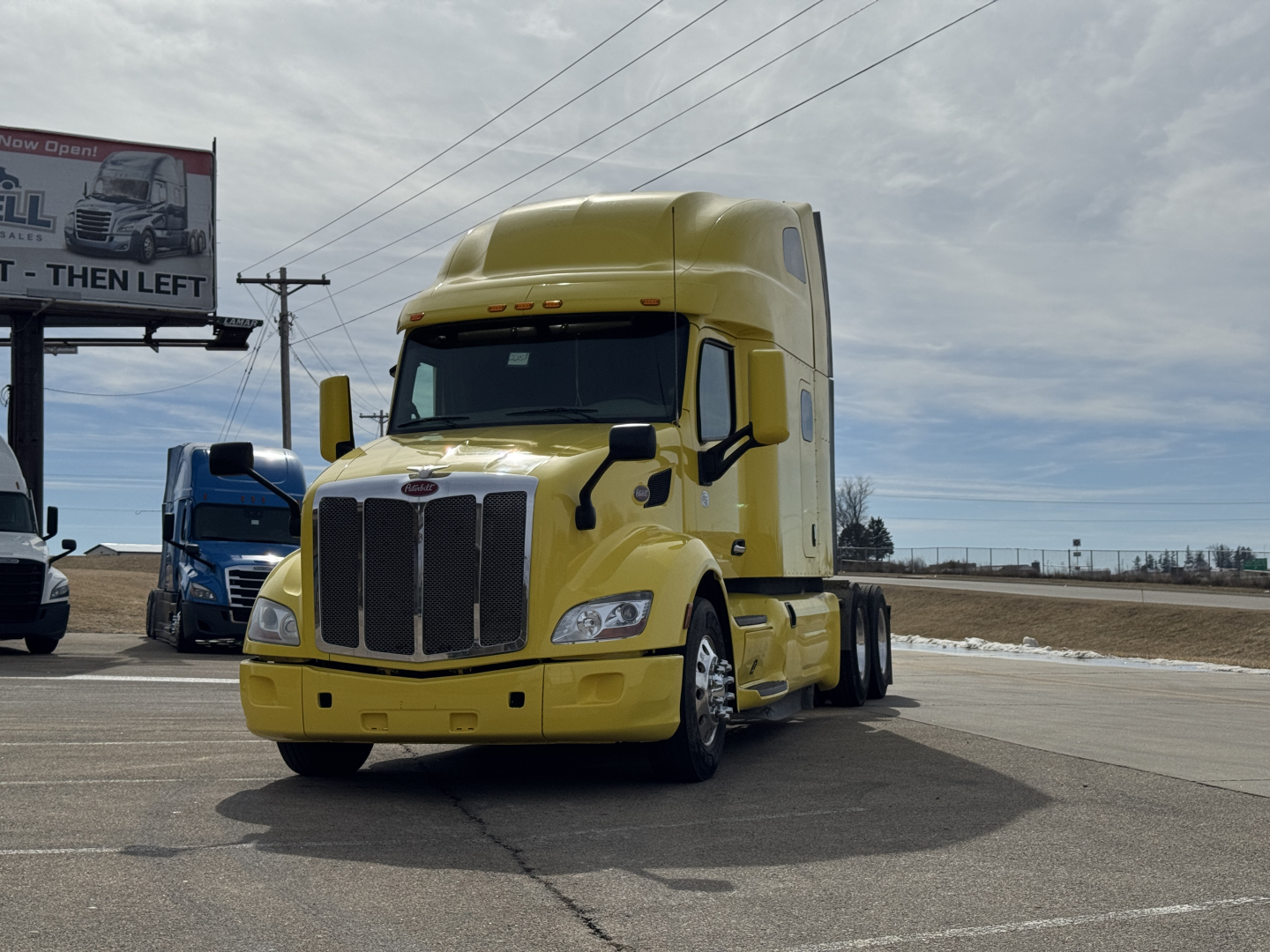 Yellow 2020 Peterbilt 579 conventional sleeper truck front view with grille, headlights, and side mirrors.