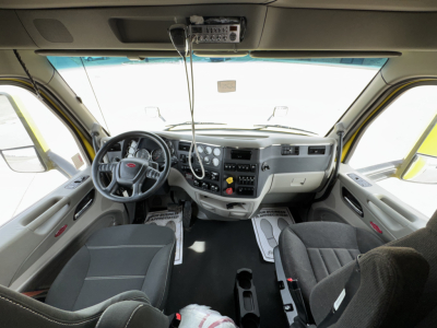 Peterbilt 579 truck interior view showing dashboard, steering wheel, and front seats.