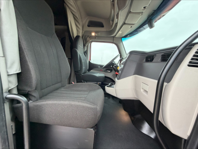 Peterbilt 579 cab interior showing driver and passenger seats, dashboard, and steering wheel.