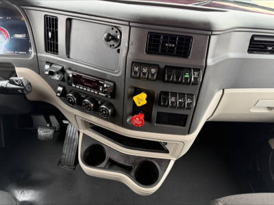 Peterbilt 579 dashboard and center console with multiple switches, gauges, and cup holders visible.