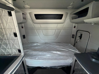Peterbilt 579 truck sleeper cab interior cargo area showing bed with plastic cover and side storage compartments