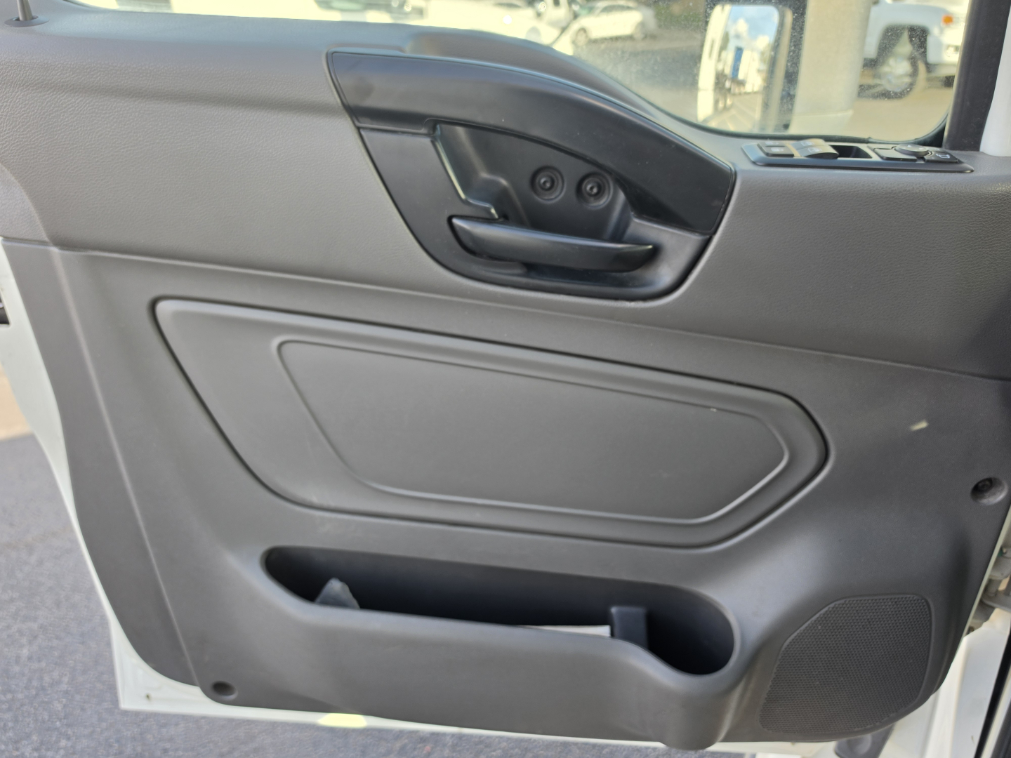 Truck interior door panel showing armrest with window/lock controls and storage pocket.